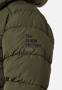 Zielona kurtka puchowa z pikowanym wzorem. Zawiera haftowany tekst "THE DENIM FACTORY" oraz "REG.TM" w kolorze czarnym i szarym.