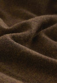 Brauner Wollstoff mit einer weichen Textur, der einen reichhaltigen, dunklen Farbton und subtile Farbvariationen auf der Oberfläche zeigt.