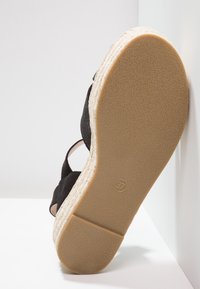 Czarna espadryla z teksturowaną zamszową cholewką i plecioną jutową podeszwą. Rozmiar 37 oznaczony na spodzie.