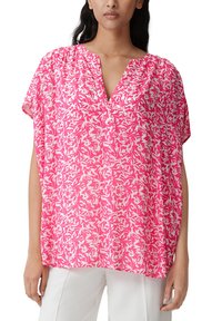 Blusa floreale rosa con maniche corte, scollo a V e vestibilità ampia. Presenta un motivo a spirale in diverse tonalità di rosa e bianco.