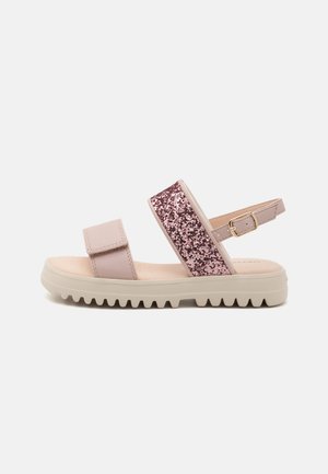 Pink sandal featuring a glittery rose gold band, adjustable ankle strap, and ridged sole for traction. Smooth material and minimalistic design.