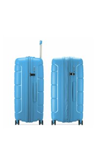 Maleta rígida azul con un diseño de surcos horizontales, doble cremallera, candado de combinación, mango retráctil y cuatro ruedas giratorias.