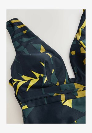Bañador navy con un profundo escote en V, que presenta patrones geométricos abstractos en amarillo y verde. Tela suave y elástica con una textura lisa.