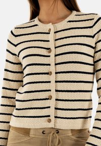 Cardigan crema con strisce navy, tessuto strutturato, scollatura rotonda e bottoni dorati per la chiusura, con polsini e orlo a costine.