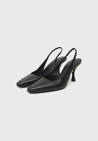 Ζευγάρι μαύρες δερμάτινες γόβες slingback με μυτερά μύτες και κυρτά μεσαίου ύψους τακούνια στιλέτο σε μονόχρωμο φόντο.