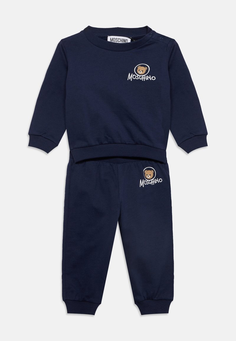 Ensemble sweat-shirt et pantalon bleu marine pour tout-petit avec poignets côtelés et logo ours Moschino sur la poitrine et la jambe du pantalon.