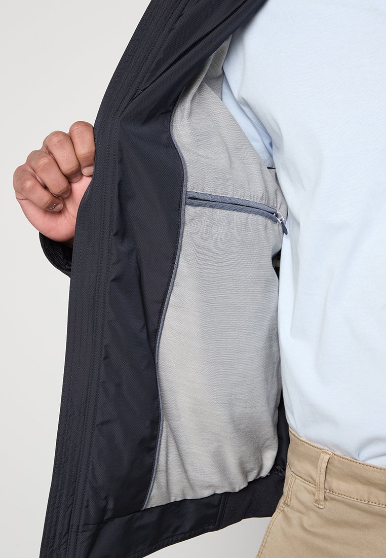Dunkelblaue Jacke mit glattem, grauem Innenfutter. Verfügt über eine Reißverschlusstasche innen und ist leicht mit einer strukturierten Passform.