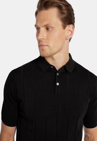 Czarna dzianinowa koszulka polo z krótkim rękawem, z pionowym prążkowanym wzorem i zapięciem na dwa guziki w kontrastowym kolorze.