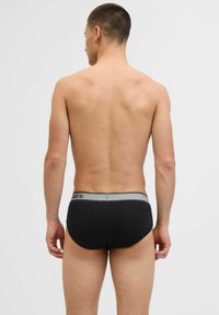 Schwarze Herrenunterhosen mit einem grauen Bund. Glattes, elastisches Material, eng geschnittenes Design mit minimalen Nähten. Die Rückansicht zeigt den Schnitt und die Form.