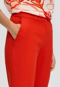 Rode op maat gemaakte broek met een gladde textuur, voorzien van zijzakken en een slank ontwerp, geschikt voor casual of formele gelegenheden.