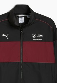 Sort og burgunder vindjakke med høj krave, frontlynlås, hvid Puma-logo og BMW Motorsport-branding på brystet.