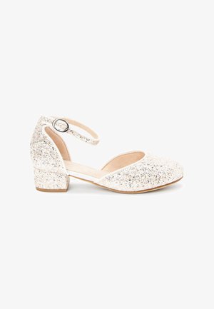 Chaussures fermées couleur champagne scintillantes avec un petit talon carré et une bride réglable à la cheville. Matériau supérieur doux et texturé.