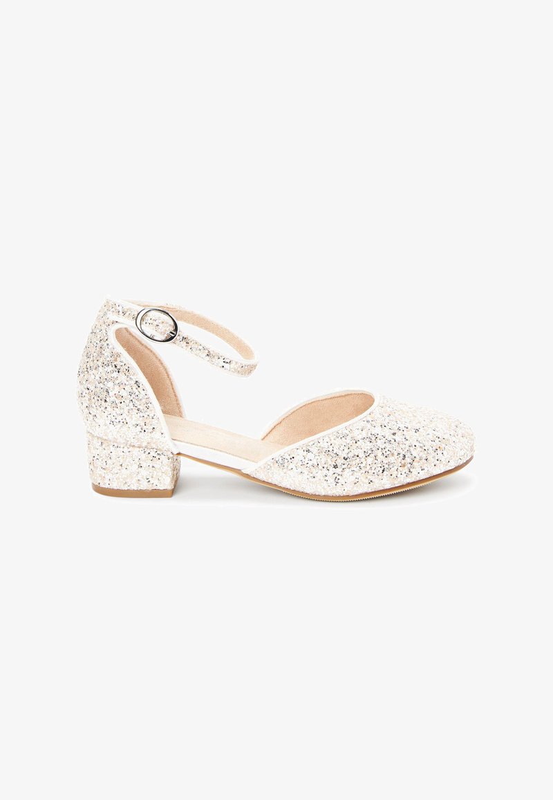 Glanzende champagnekleurige gesloten schoenen met een lage blokhak en een verstelbare enkelband. Zacht, textuur materiaal aan de bovenkant.