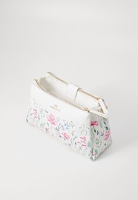 Kwiatowa torebka z białą górą z eko skóry i kwiatowym dnem z płótna w różowe, niebieskie i zielone wzory. Złoty zamek błyskawiczny i ozdoby.