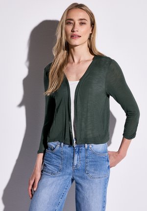 Dark green, lightweight cardigan with a V-neck and three-quarter sleeves, paired with light blue jeans featuring front pockets and faded detailing.