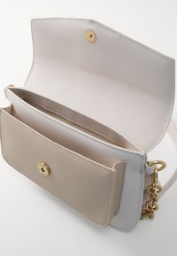 Borsa a tracolla grigio chiaro e beige con finitura testurizzata, dotata di una chiusura dorata, una singola tracolla a catena e un interno suddiviso in scomparti.