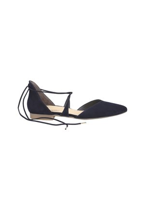 Ballerines en suède bleu marine avec un bout pointu, un talon plat et des liens en croix autour de la cheville. L'intérieur est doublé d'un beige contrastant et présente un matériel minimal.
