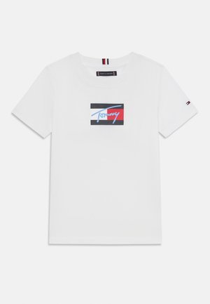 T-shirt bianca in cotone con un logo rettangolare nei colori blu, rosso e nero. Maniche corte con un piccolo logo accentato sulla manica.