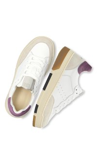 White leather sneakers with suede accents in beige and purple, featuring a textured rubber sole and traditional lace-up design.