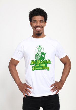 Weißes Baumwoll-T-Shirt mit einem grünen Grafikelement von St. Patrick, der ein Kleeblatt hält, und dem Text "St. Patrick is my Homeboy" in fetter, dekorativer Schrift.