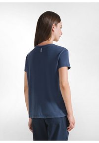 Camiseta de algodón en color azul marino, de manga corta, con cuello redondo, una etiqueta sutil en la parte posterior y un corte relajado.