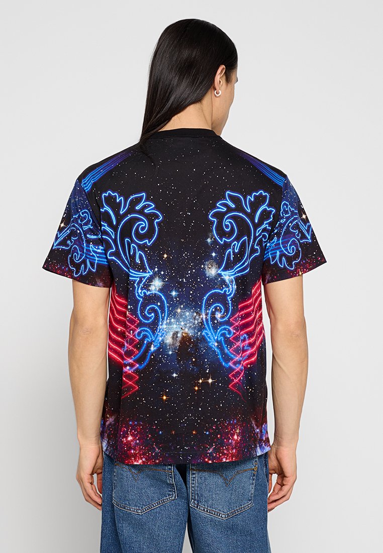 Camisa de manga corta negra con un vibrante estampado de galaxia que incluye acentos en azul y rojo neón, con patrones intrincados en la parte posterior.