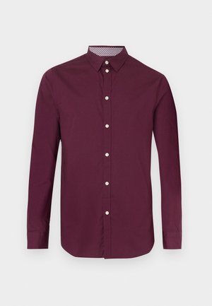 Bordeauxrode katoenen lange mouwen shirt met een knoopsluiting aan de voorkant, een kraag en een geruit accent aan de binnenkant van de kraag. Soepele textuur.