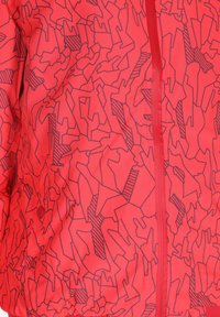 Červená větrovka s geometrickým vzorem černých linií, zapínání na zip, elastické manžety a spodní lem na stažení. Hladká textura.