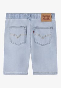 Shorts de mezclilla azul claro con cintura elástica, que cuentan con dos bolsillos traseros y costuras amarillas. Parche del logo de Levi's en la cintura.