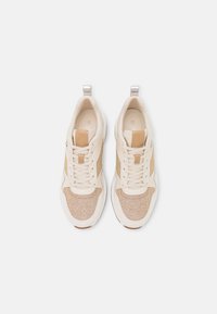 Krémové tenisky s texturovaným zlatým materiálem, bílými syntetickými detaily, kulatou špičkou a šněrovacím designem s poutkem na patě.