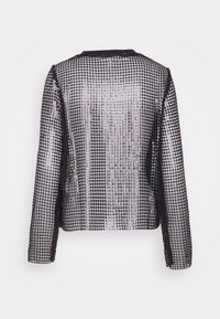 Schwarze Jacke mit silbernen Pailletten. Runder Ausschnitt, lange Ärmel und offenes Frontdesign. Dezenter Glanz und aufwendiges Paillettenmuster. 