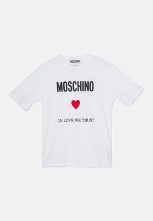 T-shirt in cotone bianco con testo nero in grassetto "MOSCHINO" e frase "IN LOVE WE TRUST" con un grafico a forma di cuore rosso centrato sotto.