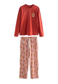 Rood shirt met lange mouwen met een peperkoekmannetje als applicatie, gecombineerd met witte broek met een herhalend patroon van peperkoekmannetjes en een rood gestreepte achtergrond.