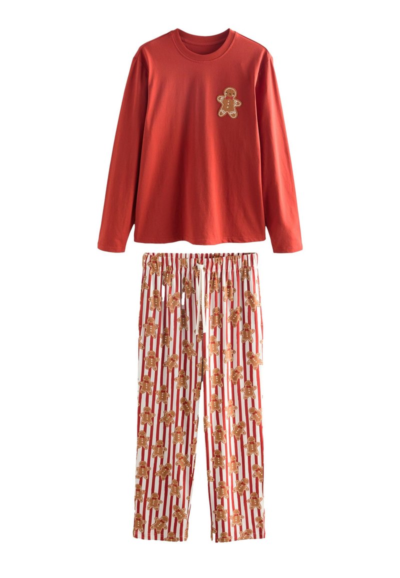 Rood shirt met lange mouwen met een peperkoekmannetje als applicatie, gecombineerd met witte broek met een herhalend patroon van peperkoekmannetjes en een rood gestreepte achtergrond.