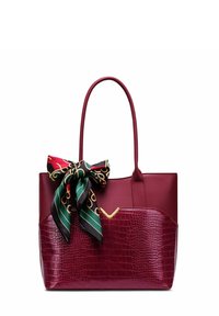 Burgundská kabelka s lesklou umělou krokodýlí strukturou, zdobená černým a zlatým šátkem s vzorem uvázaným na rukojeti.