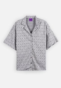 Chemise à manches courtes avec boutons, motif géométrique noir et blanc et col cranté, présentée à plat sur fond blanc.