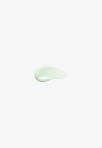 Lys grøn kosmetikcreme smurt ud med en glat, blank tekstur på en helt hvid baggrund.