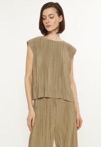 Top khaki plissettato con scollo a barca e maniche corte, caratterizzato da una vestibilità ampia e una superficie testurizzata. Tessuto morbido, lucentezza delicata.