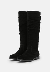 Czarne zamszowe kozaki sięgające do kolan, o luźnym kroju, z płaskim obcasem i gładką teksturą. Detale ze szwami wzdłuż łączeń.