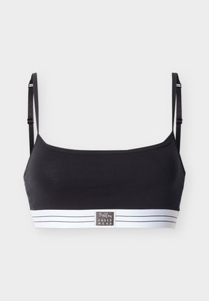 Bralette negro con tirantes finos ajustables y banda elástica blanca con rayas negras y etiqueta de marca centrada.