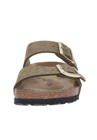 Sandales imprimées animal marron avec deux bretelles réglables, boucles métalliques, semelle en liège et semelle extérieure noire texturée.
