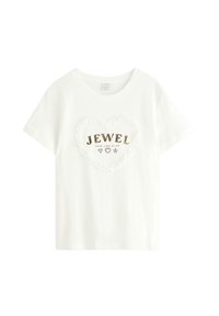 Vit bomull t-shirt med korta ärmar, med en hjärtformad, volangkant och "JEWEL" i guldbokstäver med dekorativa ikoner nedanför.