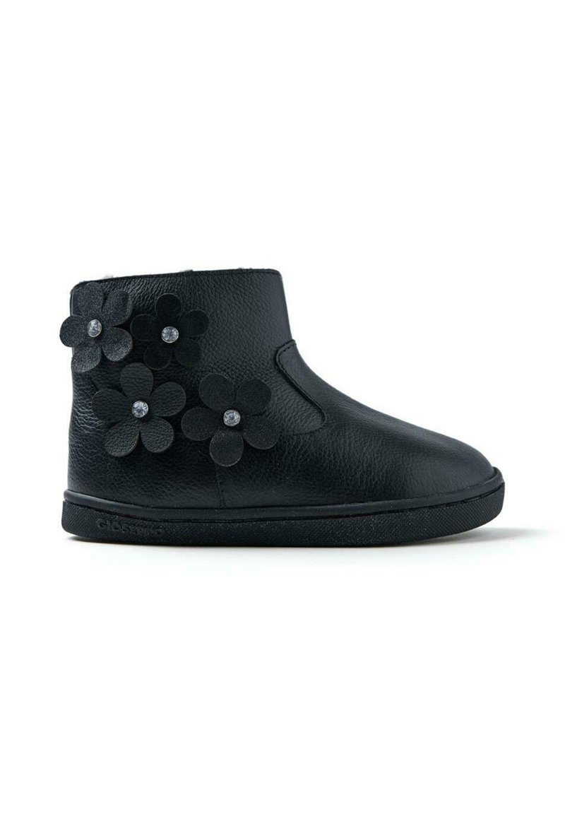 Bota de cuero negro hasta el tobillo con flores decorativas de fieltro. Presenta una puntera redonda, suela plana y un acabado texturizado. Diseño simple con acentos mínimos.