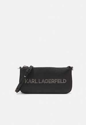 Fekete bőrtáska texturált felülettel, állítható pánttal és a "KARL LAGERFELD" logóval, amely szegecsekkel díszített az elején. Cipzáros zárás.