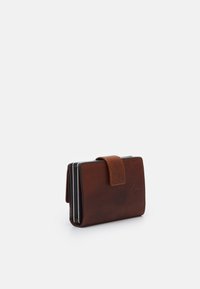 Portefeuille en cuir marron de forme rectangulaire, avec fermeture rabattable et emplacements pour cartes ; texture lisse avec un détail de marque subtil.
