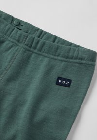 Donkergroene elastiche taillebandbroeken met een knoopdetail en een klein zwart rechthoekig label met de tekst "P.O.P" aan de zijkant.