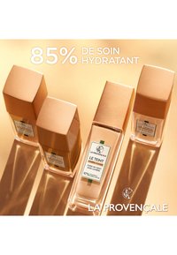 Trois flacons avec un bouchon doré et une base transparente, présentant une étiquette blanche avec des accents verts, mettant en avant un produit de fondation de La Provençale.