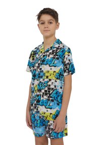 Set di pigiama a maniche corte con un motivo graffiti in nero, blu e giallo su tessuto leggero. Include il colletto e pantaloni a shorts coordinati.