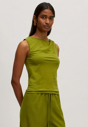 Green sleeveless top with a round neckline and fitted design. Made from smooth fabric, it features subtle draping at the shoulders.
