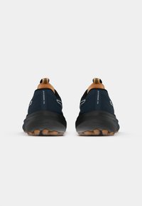 Chaussures de course bleu foncé avec des semelles noires et des accents beige. Présentent un dessus texturé, une languette en boucle au niveau du talon et une conception légère pour un bon soutien.